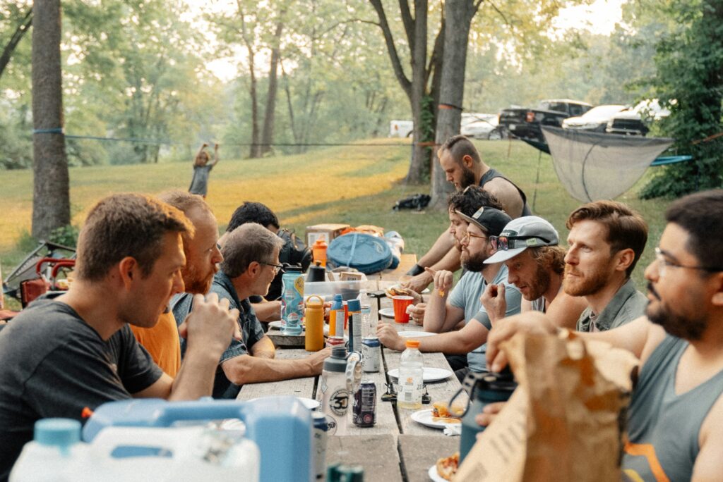 People eating around a picnic table